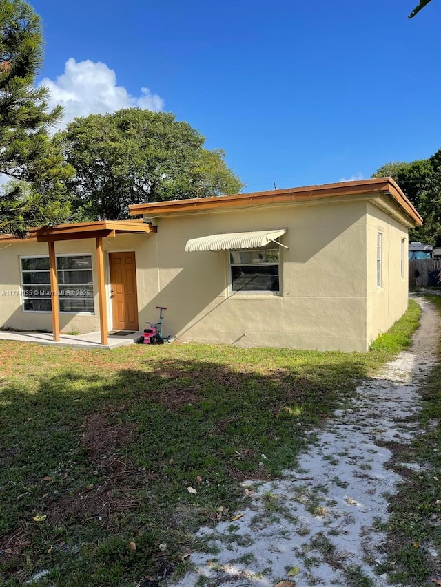 2801 Mayo St, Hollywood, FL 33020 - back of house featuring a lawn and stucco siding
