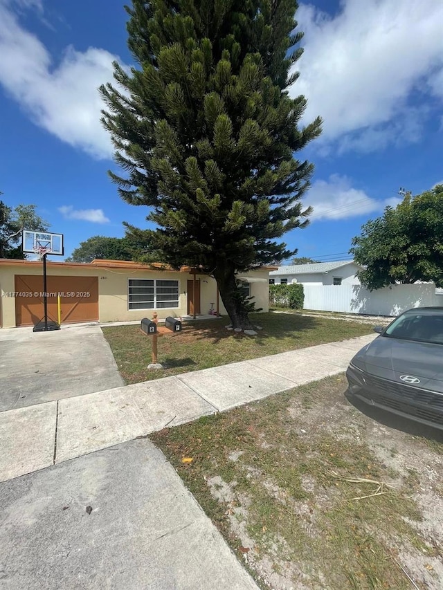 2801 Mayo St, Hollywood, FL 33020 - view of front of house featuring a front yard, stucco siding, and fence