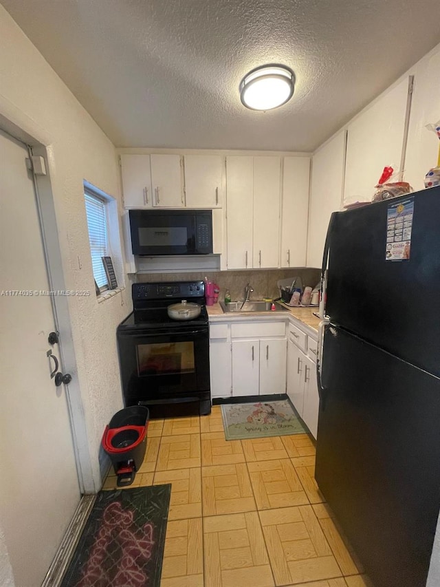 2801 Mayo St, Hollywood, FL 33020 - kitchen with light countertops, white cabinets, black appliances, light floors, and a sink