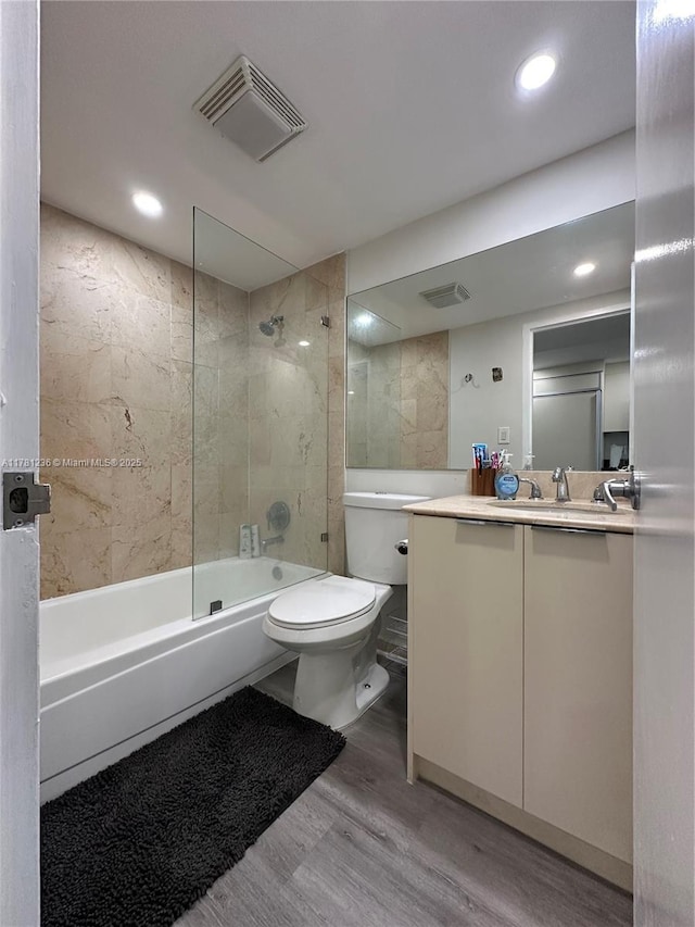 bathroom featuring vanity, shower / washtub combination, toilet, visible vents, and wood finished floors