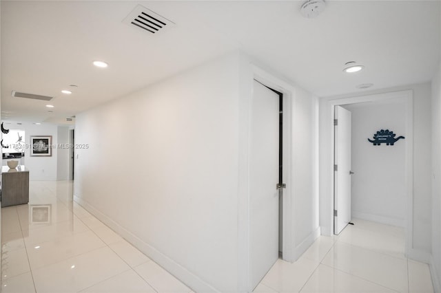 hallway featuring visible vents, recessed lighting, baseboards, and light tile patterned floors