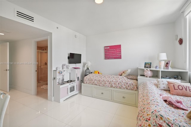 bedroom featuring visible vents, light tile patterned floors, and ensuite bathroom