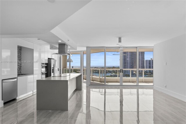 21055 Yacht Club Dr Unit 1409, Aventura, FL 33180 - kitchen featuring a water view, modern cabinets, island exhaust hood, white cabinets, and appliances with stainless steel finishes