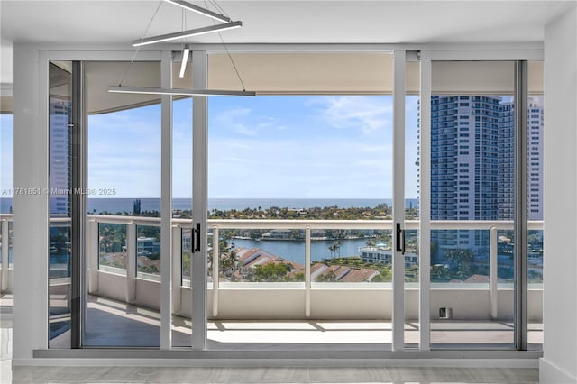 21055 Yacht Club Dr Unit 1409, Aventura, FL 33180 - doorway to outside with a wall of windows, a water view, and a wealth of natural light