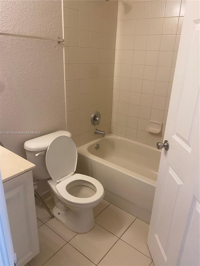 full bath featuring a textured wall, toilet, tile patterned floors, vanity, and bathtub / shower combination