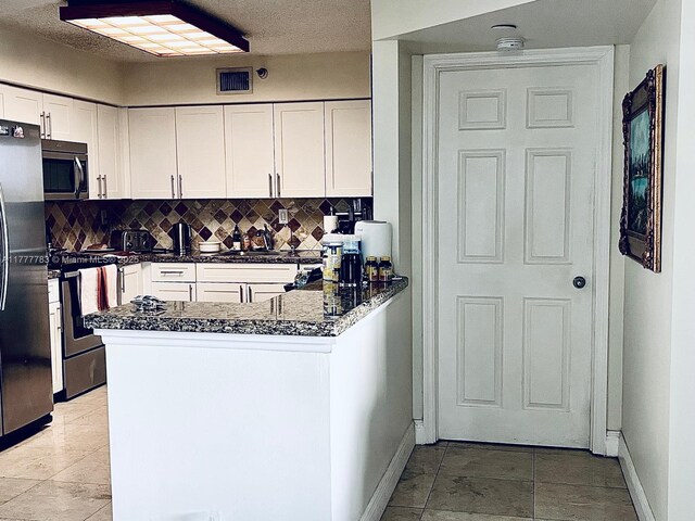 3530 Mystic Pointe Dr Unit 408, Aventura, FL 33180 - kitchen with stainless steel appliances, visible vents, baseboards, and backsplash