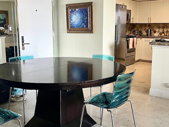 3530 Mystic Pointe Dr Unit 408, Aventura, FL 33180 - kitchen with white cabinets, appliances with stainless steel finishes, light tile patterned flooring, dark countertops, and decorative backsplash