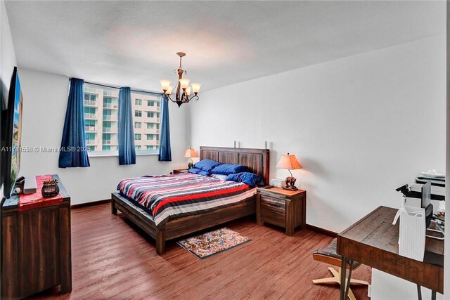 1755 E Hallandale Beach Blvd Unit 1608E, Hallandale Beach, FL 33009 - bedroom with a chandelier, wood finished floors, and baseboards