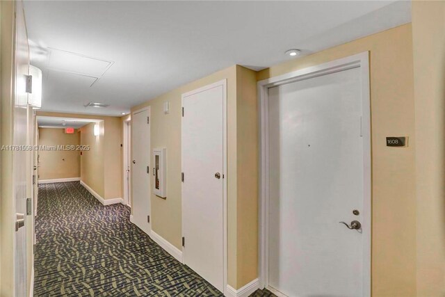 1755 E Hallandale Beach Blvd Unit 1608E, Hallandale Beach, FL 33009 - hallway featuring attic access, dark carpet, and baseboards