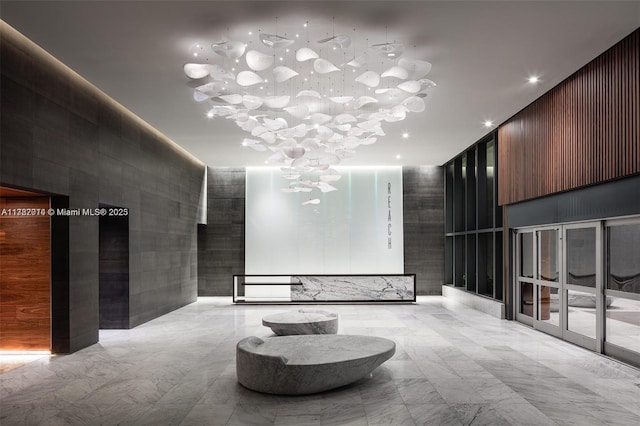 68 SE 6th St Unit 810, Miami, FL 33131 - community lobby featuring a high ceiling, tile walls, and recessed lighting