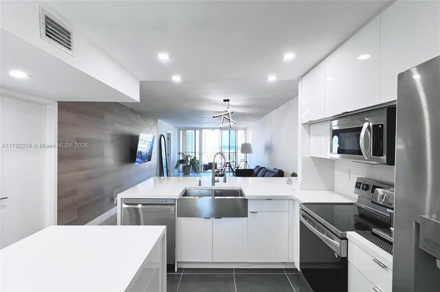 121 Golden Isles Dr Unit 803, Hallandale Beach, FL 33009 - kitchen with appliances with stainless steel finishes, a sink, an accent wall, a peninsula, and recessed lighting
