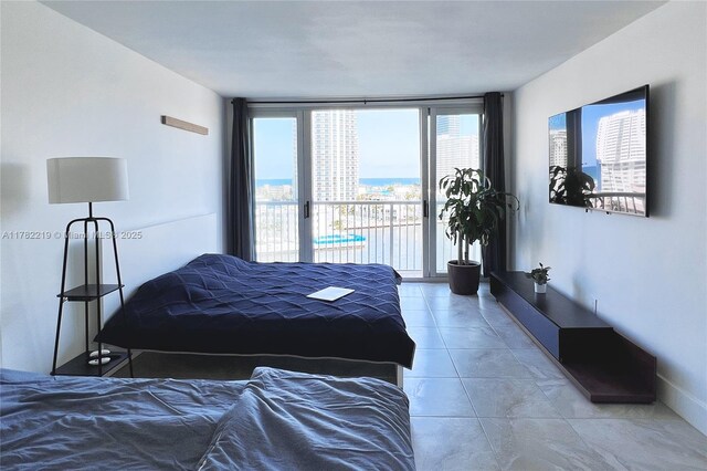 121 Golden Isles Dr Unit 803, Hallandale Beach, FL 33009 - bedroom featuring access to outside, expansive windows, and light tile patterned floors