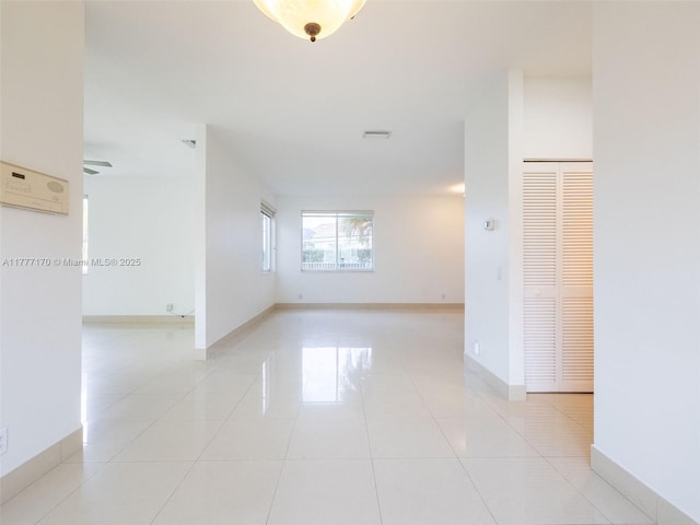 spare room with light tile patterned floors and baseboards
