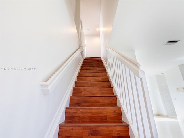 stairway with wood finished floors and visible vents