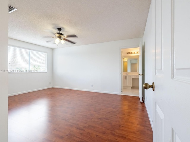 empty room with visible vents, baseboards, a ceiling fan, a textured ceiling, and wood finished floors
