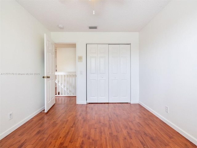 4242 Magnolia Ridge Dr, Weston, FL 33331 - unfurnished bedroom with wood finished floors, a closet, and a textured ceiling