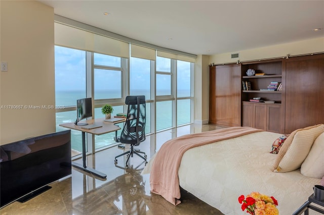 bedroom featuring a barn door, visible vents, multiple windows, and expansive windows