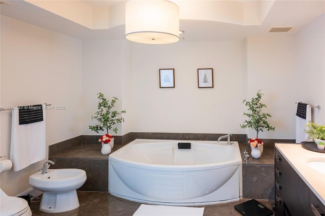 full bath featuring visible vents, vanity, toilet, a bath, and a bidet