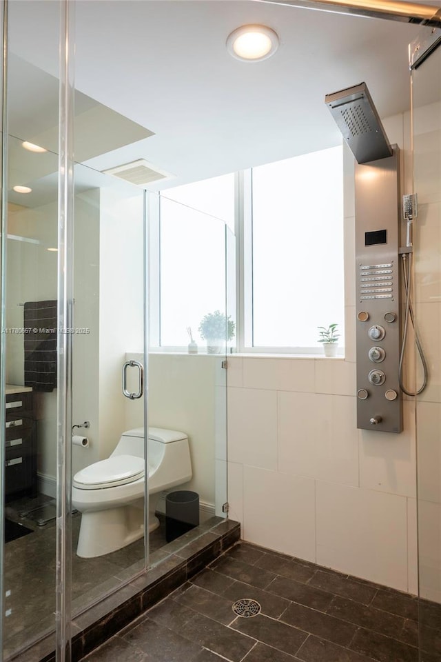 bathroom featuring recessed lighting, a stall shower, and toilet