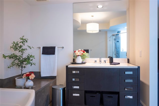 bathroom featuring vanity, a tub, and a stall shower
