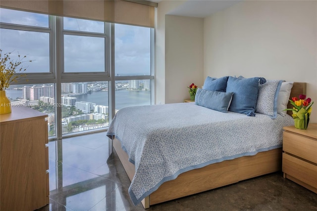 bedroom featuring a view of city and a wall of windows