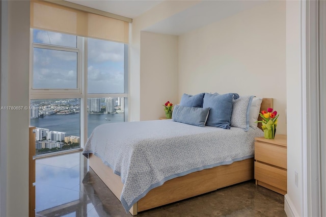 bedroom with a water view, floor to ceiling windows, and concrete flooring