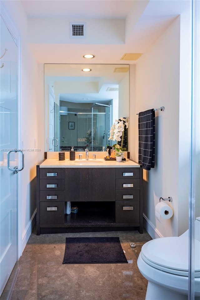 full bath with vanity, toilet, baseboards, visible vents, and a stall shower