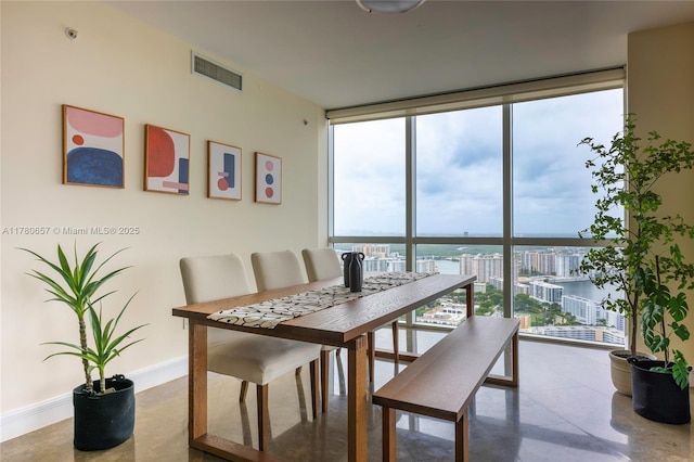 dining area with visible vents, baseboards, and a wall of windows