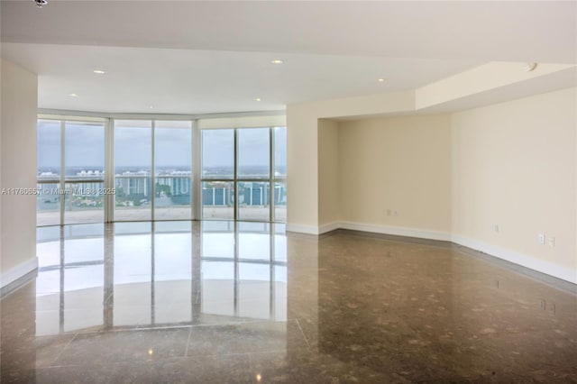 unfurnished room featuring recessed lighting, baseboards, and floor to ceiling windows