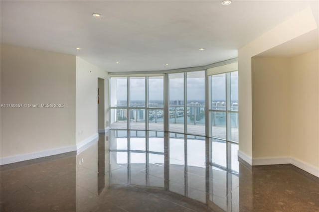 empty room featuring recessed lighting and baseboards