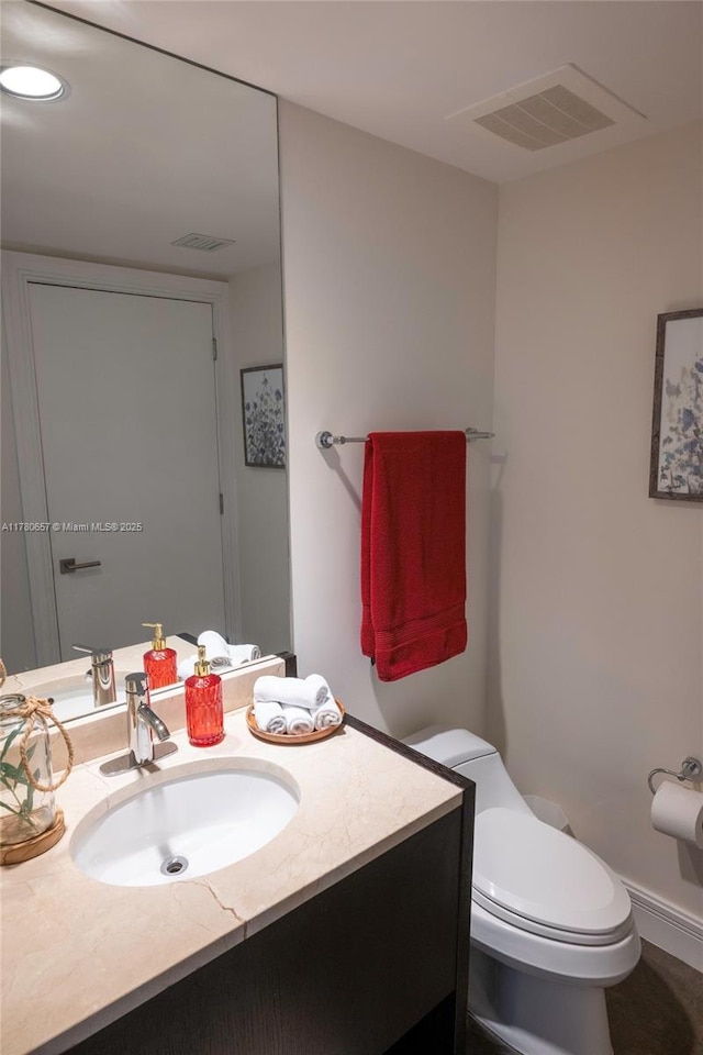 bathroom featuring toilet, visible vents, and vanity