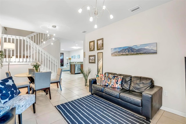 living room featuring visible vents, a notable chandelier, light tile patterned floors, and stairs