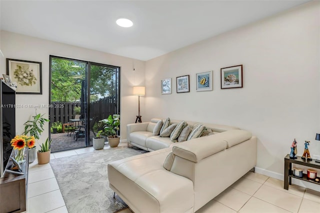 living area featuring light tile patterned floors and baseboards