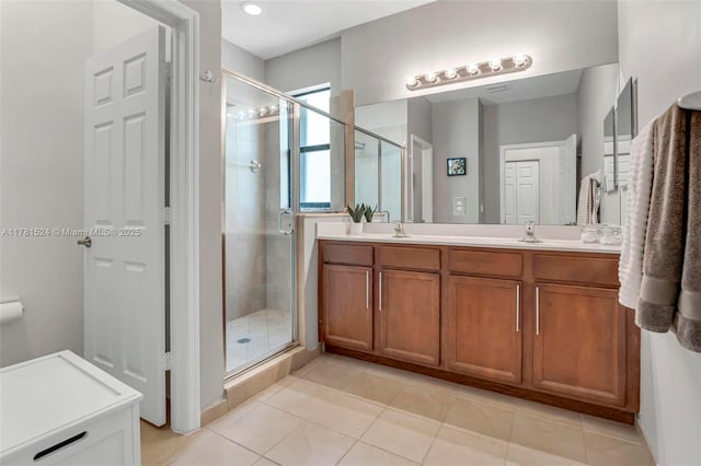 full bathroom with a stall shower, double vanity, a sink, and tile patterned floors