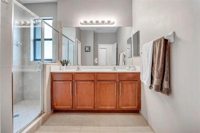 bathroom with a stall shower, double vanity, a sink, and tile patterned flooring