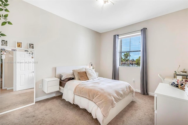 bedroom with light colored carpet and baseboards
