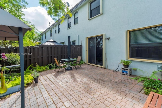 view of patio / terrace featuring outdoor dining space, a gazebo, and fence