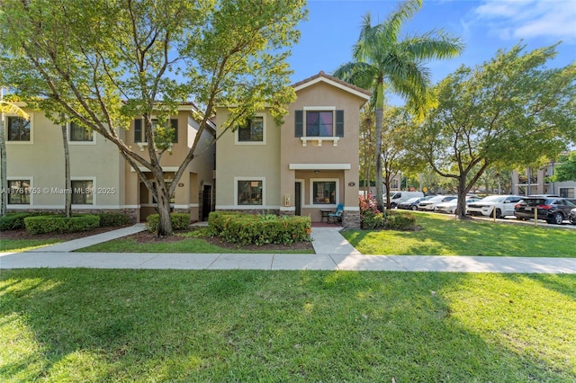 townhome / multi-family property featuring stucco siding, a front lawn, and uncovered parking