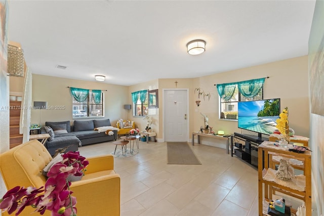 living area featuring light tile patterned flooring, visible vents, and a healthy amount of sunlight