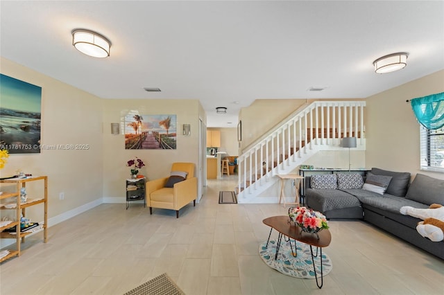 living room featuring stairway, visible vents, and baseboards