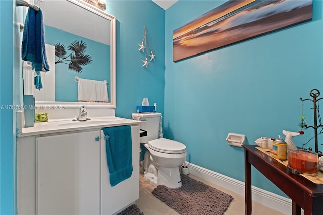 bathroom with baseboards, toilet, and vanity