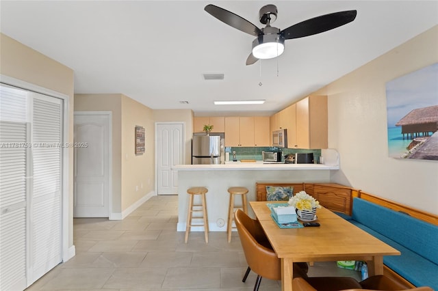dining space featuring a toaster, visible vents, a ceiling fan, light tile patterned flooring, and baseboards