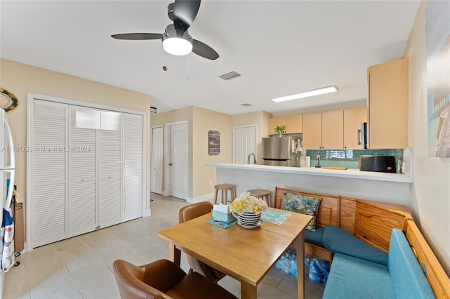 dining space with light tile patterned floors, visible vents, and ceiling fan