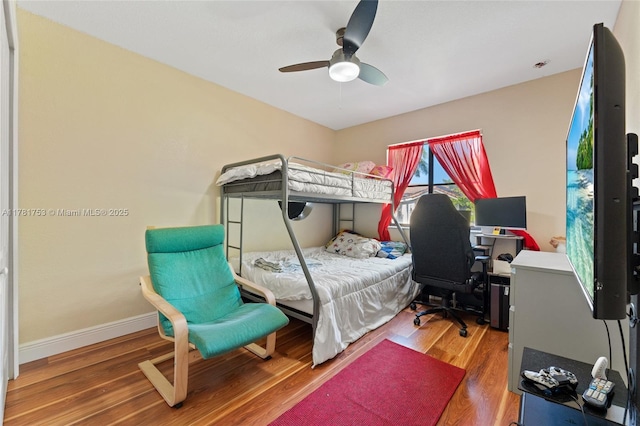 bedroom featuring wood finished floors, baseboards, and ceiling fan