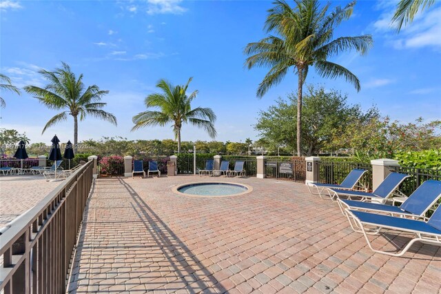 view of swimming pool featuring a hot tub, a patio, and fence