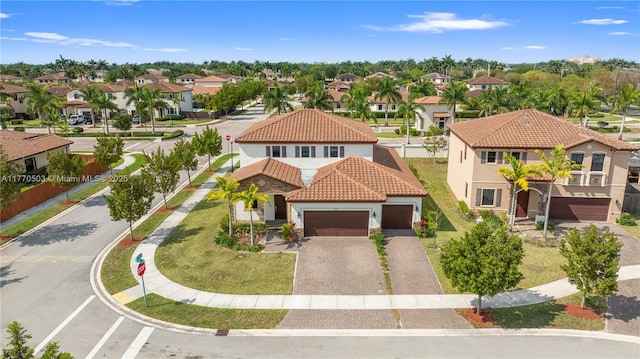 view of front of house with a residential view, stucco siding, driveway, a garage, and a tiled roof
