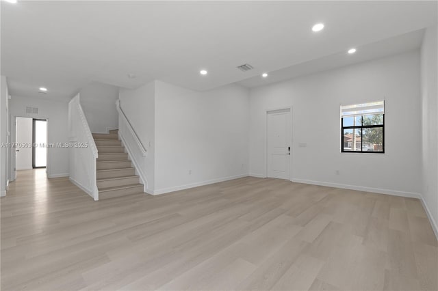 spare room with visible vents, light wood-type flooring, recessed lighting, and stairs