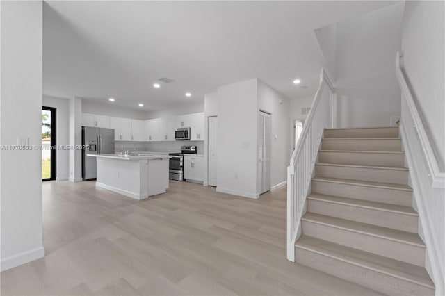 kitchen featuring light countertops, white cabinets, appliances with stainless steel finishes, and recessed lighting