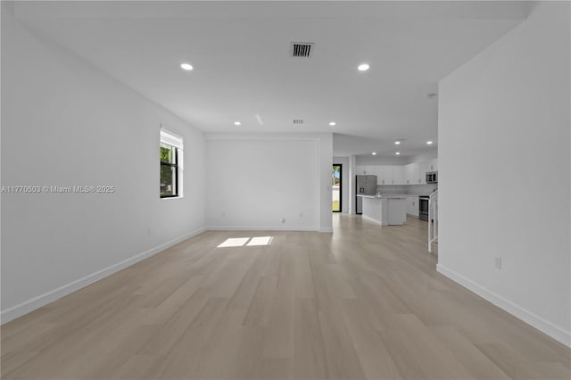 unfurnished living room with light wood-style flooring, recessed lighting, and baseboards