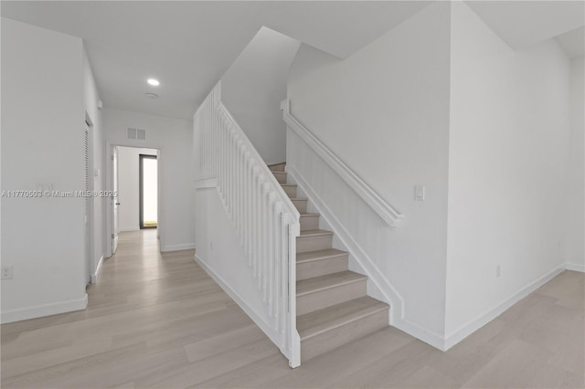 stairs with wood finished floors, baseboards, visible vents, and recessed lighting